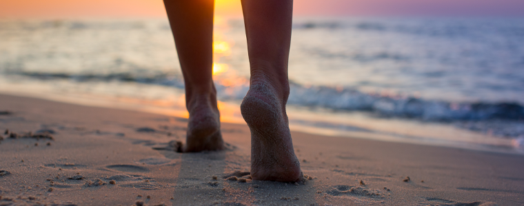 woman walking beach sunset