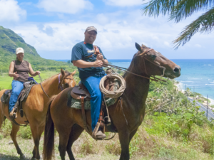 tourists ride a scenic drive in oahu on horseback. 